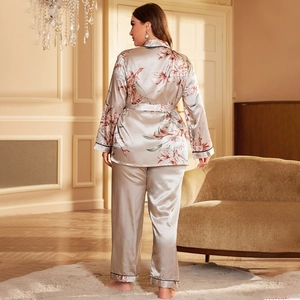Champagne floral satin pajama set with long sleeves and black trim in a home setting