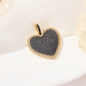 Macro view of a 14k gold-plated heart pendant with blue and white zircon micro-inlay