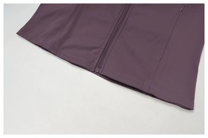 Détail de l'ourlet de la veste de yoga mauve avec poche zippée invisible et double couture