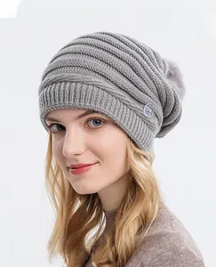 Détail du bonnet en tricot gris avec texture côtelée et grand pompon en fausse fourrure