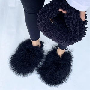 Top view of plush black faux fur handbag with mop-style texture and matching furry slides