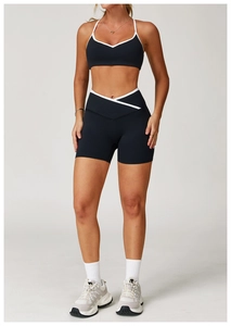 Detail van de high-waist yogashort met witte contrasttrim en zwarte compressiestof