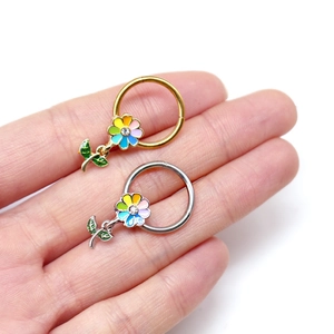 Vue détaillée des anneaux de mamelon fleurs colorées en or et argent avec des strass brillants