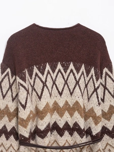 Detailed view of brown geometric jacquard knit pattern and thin leather belt on the sweater