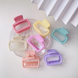 Detailed top view of seven matte macaron square hair claws on a textured shell plate