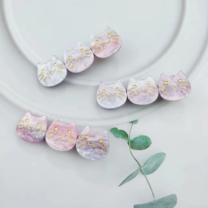 Macro view of purple and pink marble textured acetate cat hair clips on a white plate