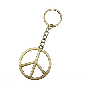 Vintage bronze peace sign keychain with metal ring isolated on white background