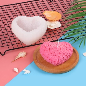 Detail of 3D woven heart silicone mold with finished floral scented candle on colorful backdrop