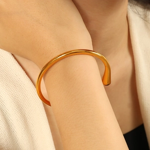 Bracciale rigido dorato in acciaio inossidabile con estremità a goccia sul polso