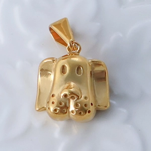 Macro shot of a 24k gold plated stainless steel dog head pendant with polished finish