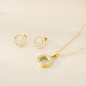 Dettaglio di parure con collana e orecchini a lobo tondi dorati con zirconi brillanti