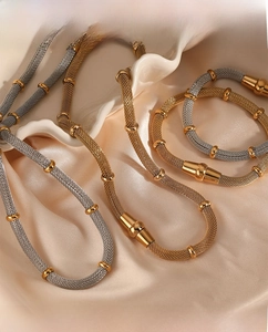 Detail of bicolored metallic mesh necklace and bracelet set with magnetic clasps
