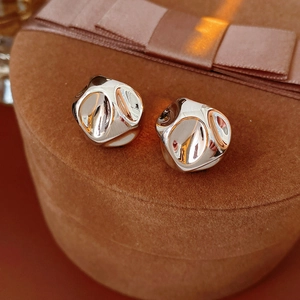Detail of irregular faceted silver earrings on a brown velvet jewelry box base