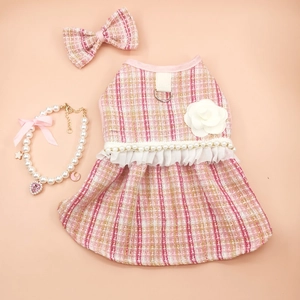 Detailed set featuring pink tweed dog dress with camellia flower and pearl necklace