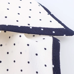 Détail du tissu blanc à pois bleu marine avec des coutures de bordure de haute qualité