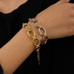 Gros plan de bracelets à maillons épais or et argent avec texture métallique