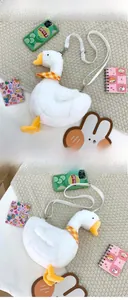 Detail of plush white goose crossbody bag with yellow beak and soft faux fur texture