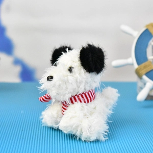 Detailed macro shot of fluffy white Westie dog plush keychain with a red striped scarf