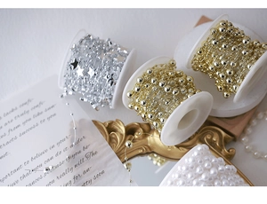 Detailed view of DIY bead chains featuring gold beads, silver stars and white faux pearls