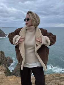 Veste rétro en peau lainée marron pour femme sur une falaise pour l'automne-hiver