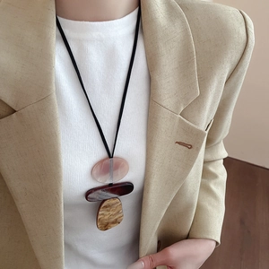 Close-up of a geometric resin pendant necklace with artistic translucent textures