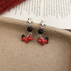 Detail of red pony earrings with silver star and black bead on textured paper card