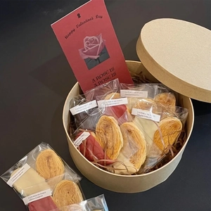 Detailed view of Kraft paper box filled with assorted palmiers and Valentine's Day card