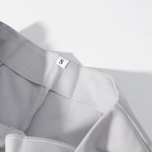 Detailed close-up of gray suit pants waist featuring neat stitching and size S label