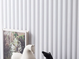 Statues de chevaux en céramique sur un bureau avec des panneaux muraux rainurés blancs