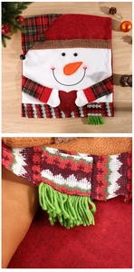 Macro detail of snowman chair cover with knit scarf and festive patterns for Christmas decor