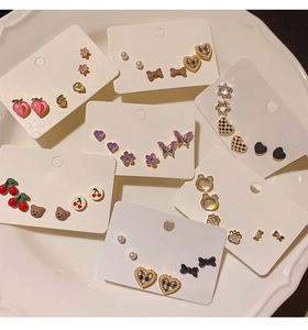 Detailed view of S925 needle earring set featuring heart, butterfly, and pearl designs