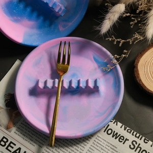 Détail d'un plateau en résine marbré rose et bleu avec support pour bijoux ou stylos