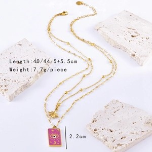 Detail of pink rectangular pendant with star motifs on golden double layer chain