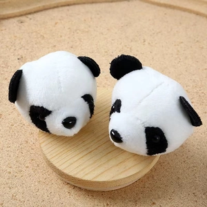 Close-up of cute panda plush head decorations on a natural round wooden stand