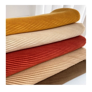 Macro detail of pleated texture on winter scarves in mustard, beige, and earthy tones