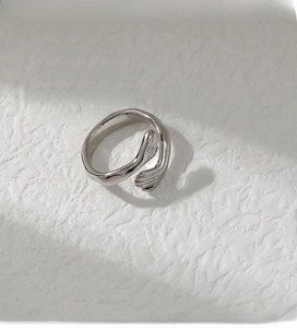 Macro shot of silver minimalist embrace hands design open ring with polished finish