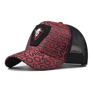 Casquette trucker rétro rouge et noire avec emblème tête de mort et motif SOIGNE