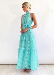 Detail of mint green halter maxi dress featuring textured jacquard fabric and bow waist
