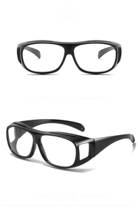 Front and 45-degree side views of black frame safety goggles with transparent lenses