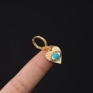 Close-up of gold heart-shaped evil eye earring with rainbow pave zircons and turquoise