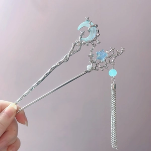 Detail of silver moon and star hair stick with blue beads and flowing tassels