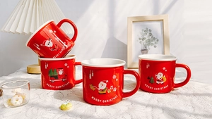 Close-up of four red Christmas ceramic mugs with festive illustrations and white interior