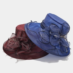 Détail de chapeaux de soleil français en organza bleu roi et rouge avec de grandes fleurs