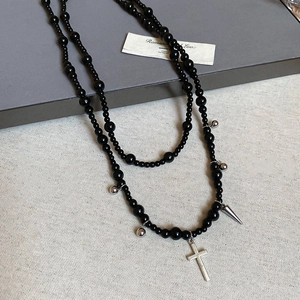 Detailed macro view of Y2K gothic necklace featuring black glass beads and silver crosses