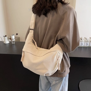 Detail of beige corduroy shoulder bag showing soft texture and decorative woven knot