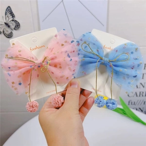 Détail de nœuds à cheveux en tulle pailleté rose et bleu avec petits pompons pour filles