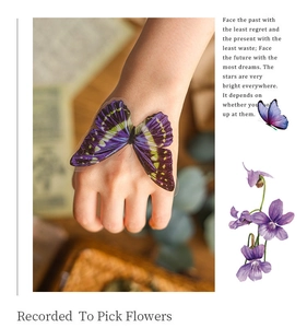 Detailed view of a purple butterfly PET sticker on hand for vintage scrapbooking decor