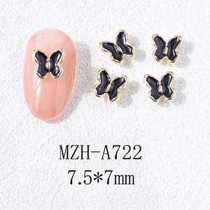 Vue macro de bijoux d'ongles papillon en émail noir 3D avec bordure dorée élégante