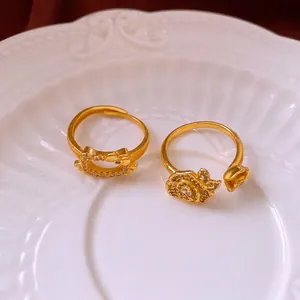 Gold plated flower and kitty rings with zircon inlay on a white ceramic plate