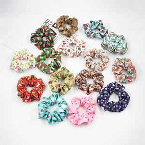 Detailed view of fifteen colorful Christmas patterned elastic fabric hair scrunchies